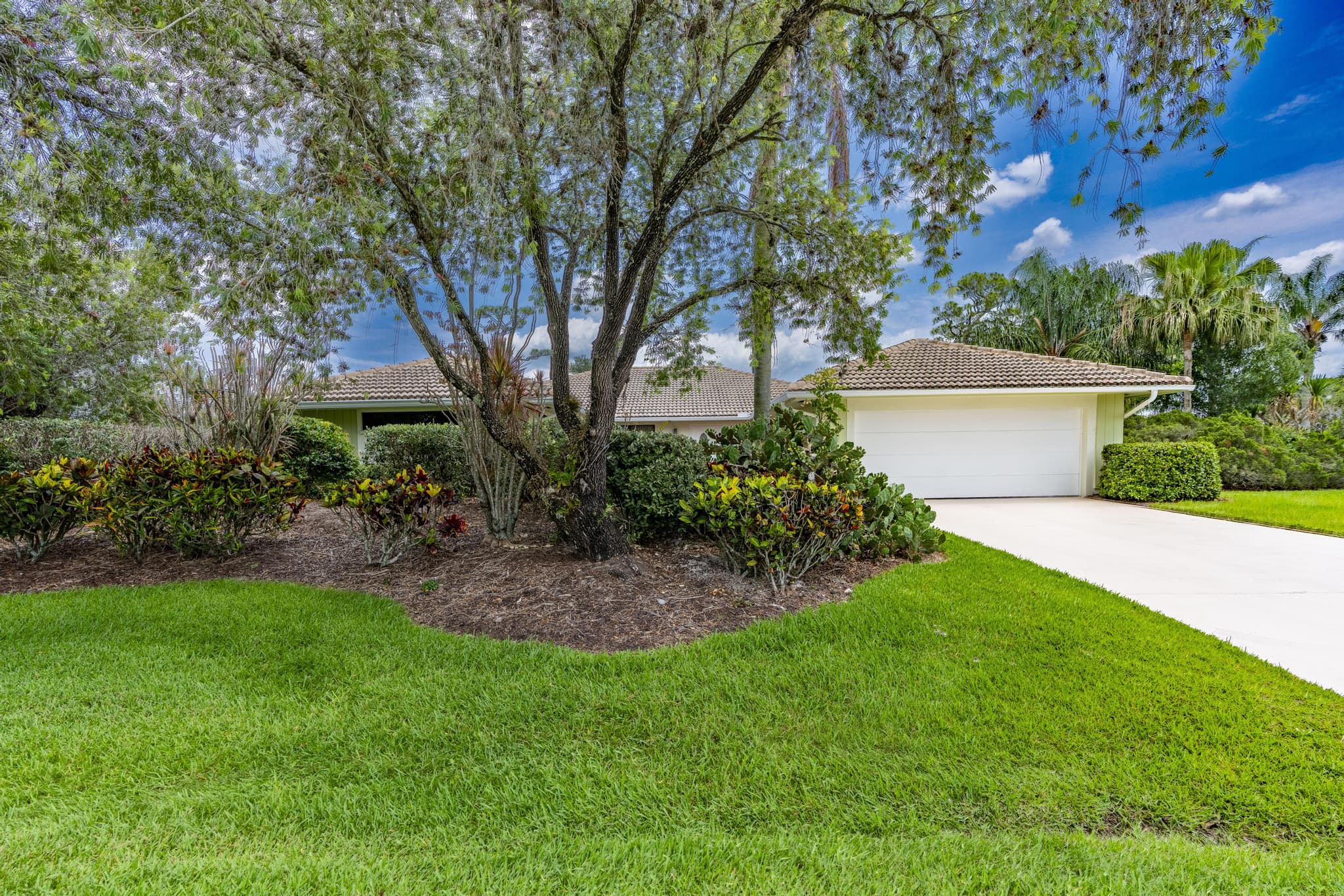 Front elevation of 1543 SW Troon Cir with mature landscaping
