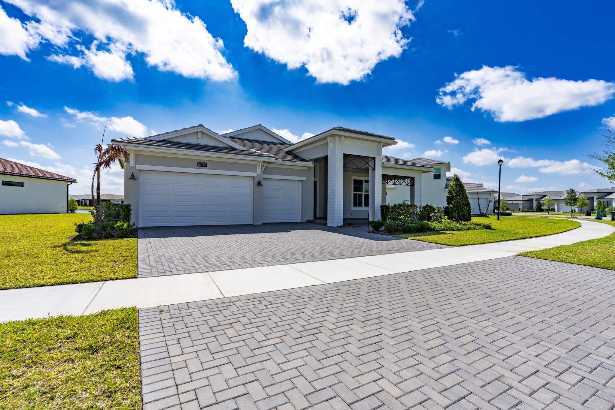 New construction front elevation with paver drive at 8580 SW Cantante Way